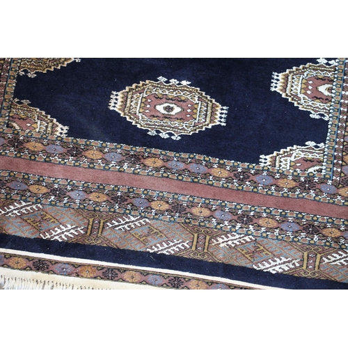 418 - Bokhara rug, the row of cream geometric guls on a blue field within geometric borders, 215cm x 130cm... 