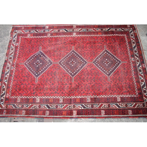 420 - Persian nomad tribal rug, the three central medallions on a red ground, 307cm x 215cm.