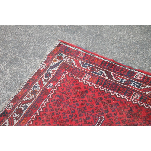 420 - Persian nomad tribal rug, the three central medallions on a red ground, 307cm x 215cm.