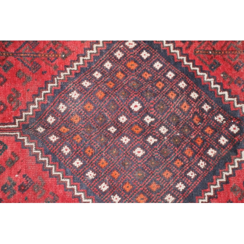 420 - Persian nomad tribal rug, the three central medallions on a red ground, 307cm x 215cm.