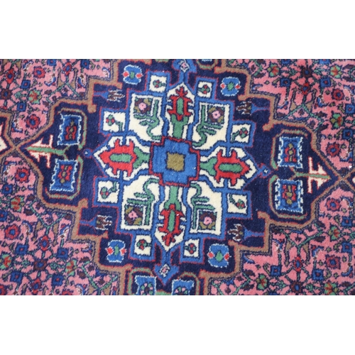 421 - Persian rug, the cream and blue central medallion on a light red ground with repeating floral patter... 