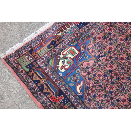 421 - Persian rug, the cream and blue central medallion on a light red ground with repeating floral patter... 