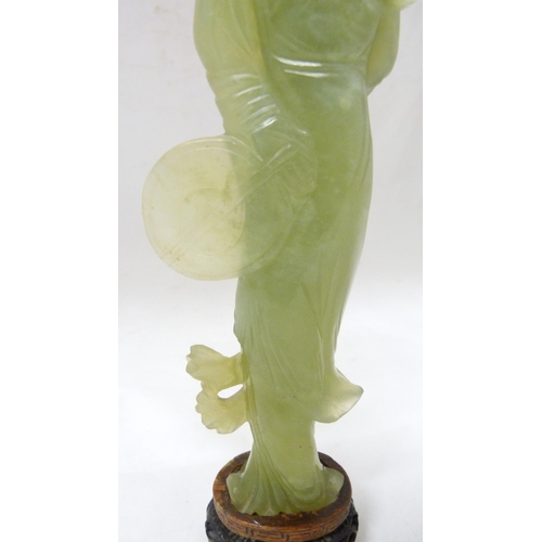 352 - Chinese carved lime jade figure of a Geisha, probably Republic period, holding a lotus flower in her... 