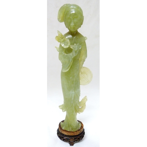 352 - Chinese carved lime jade figure of a Geisha, probably Republic period, holding a lotus flower in her... 