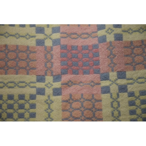 294 - Welsh wool blanket, double sided and fringed with geometric decoration on a polychrome grid backgrou... 