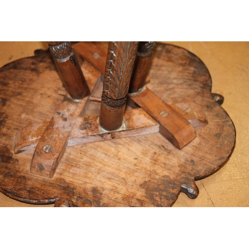 366 - Indian teak occasional small table, the shaped top carved with a foliate field around a mythological... 