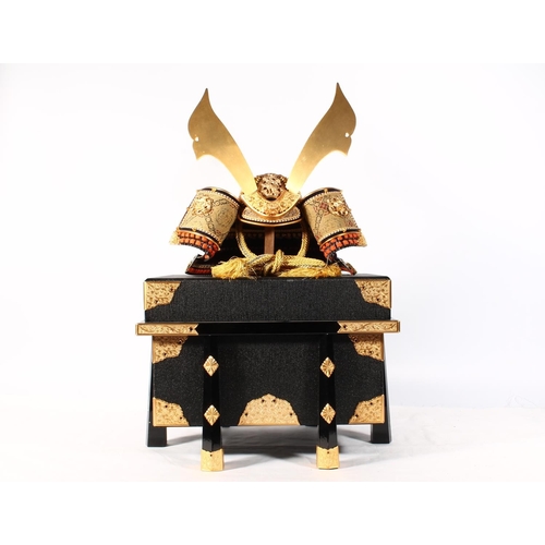 1457 - Model of a Japanese Samurai kabuto helmet, 32cm tall, held in a gilt metal bound black lacquer box.