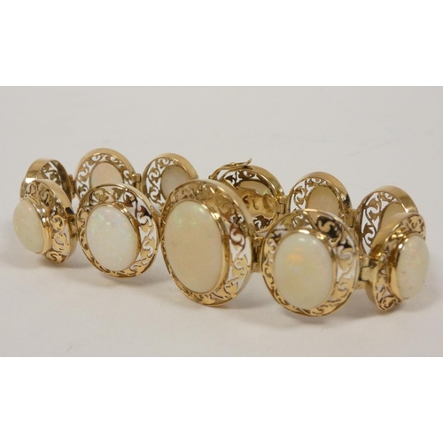 40 - Gold bracelet with eleven graduated opals, in pierced oval panels, probably 14ct. 17g gross