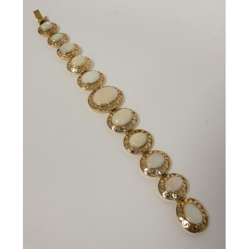 40 - Gold bracelet with eleven graduated opals, in pierced oval panels, probably 14ct. 17g gross