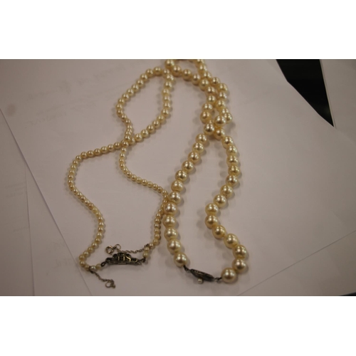 168 - Single strand pearl necklace with Art Deco style white metal closure set with diamonds, and a single... 