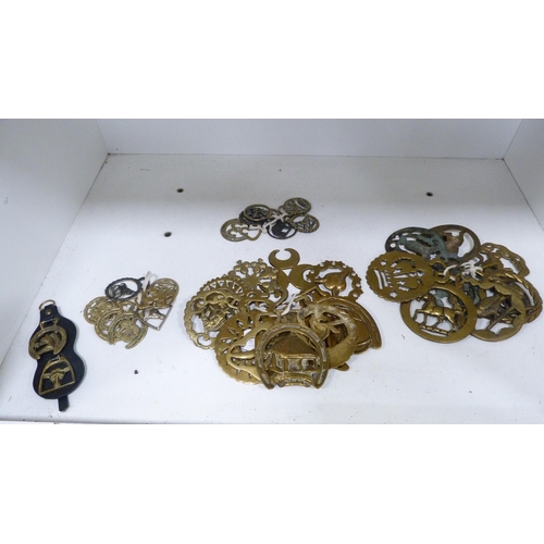 123 - Collection of various horse brasses, some on straps (one shelf).