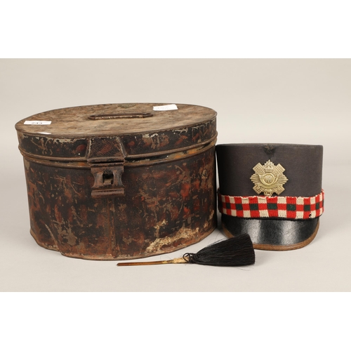 243 - Highland Light Infantry shako cap with badge and feather hackle, in carrying tin