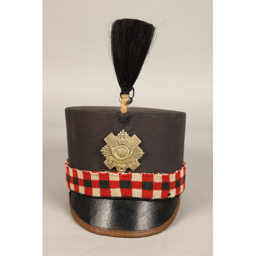 243 - Highland Light Infantry shako cap with badge and feather hackle, in carrying tin