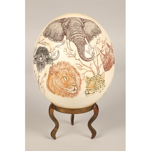 247 - Two scrimshaw ostrich eggs, one carved with Sudan design and another with Safari animals