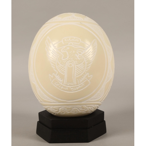 247 - Two scrimshaw ostrich eggs, one carved with Sudan design and another with Safari animals