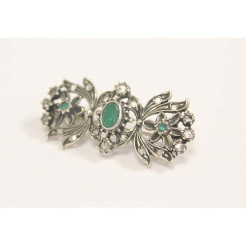 94 - Continental silver floral brooch with three collet set emeralds surrounded by old cut diamonds.