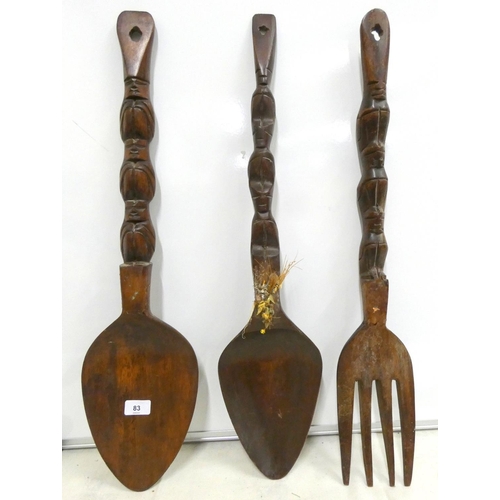 83 - Two large carved spoons and a large fork.