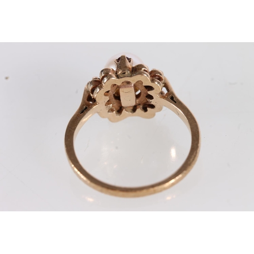 503 - 9ct gold ring set with large spherical pearl on a flowerhead mount, ring size K, 3g gross.