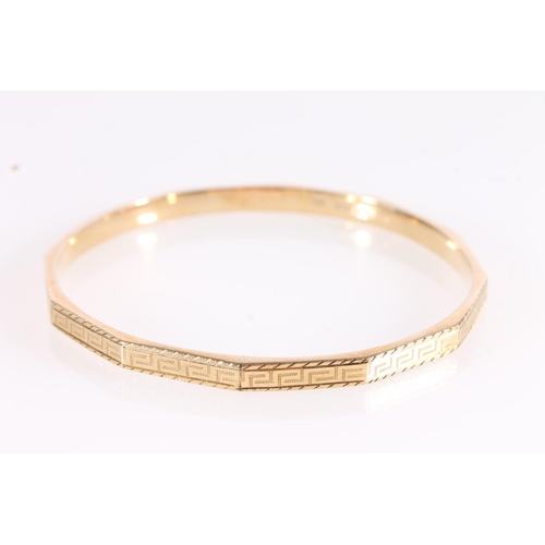 521 - 9ct gold bangle with Greek key engraved design, internal W7cm, 8.4g.