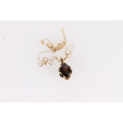 523 - 9ct gold and oval smoky quartz pendant on fine gold chain.