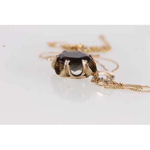 523 - 9ct gold and oval smoky quartz pendant on fine gold chain.