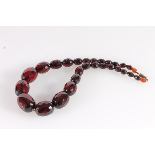 559 - Cherry amber Bakelite or Lucite faceted bead necklace, largest bead 2.8cm, gross 74g.