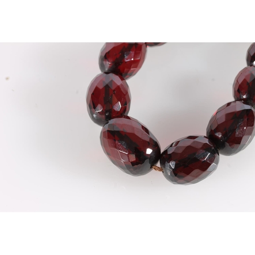 559 - Cherry amber Bakelite or Lucite faceted bead necklace, largest bead 2.8cm, gross 74g.