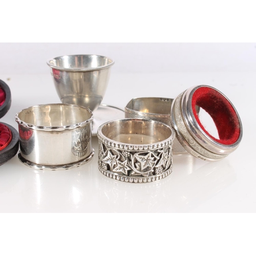 591 - Pair of hallmarked silver butter knives, silver egg cup and four silver napkin rings, silver weight ... 