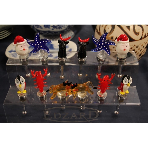 54 - Edzard novelty glass bottle stoppers on stand.