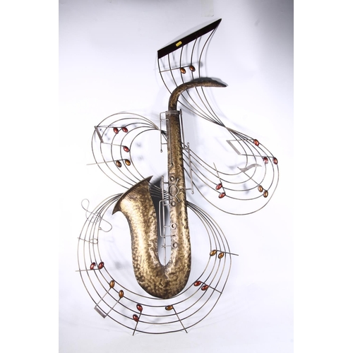 75 - Large beaten metal wall ornament in the form of a saxophone encircled by musical notes, 125cm high.