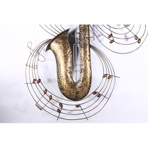 75 - Large beaten metal wall ornament in the form of a saxophone encircled by musical notes, 125cm high.