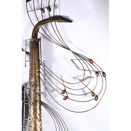 75 - Large beaten metal wall ornament in the form of a saxophone encircled by musical notes, 125cm high.