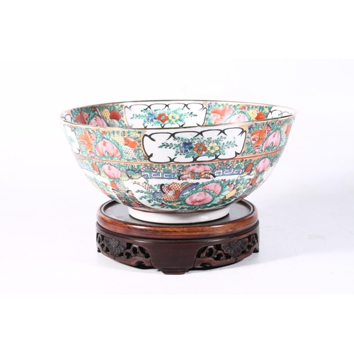 117 - 20th century Chinese famille rose porcelain bowl on hardwood base, 26cm wide.