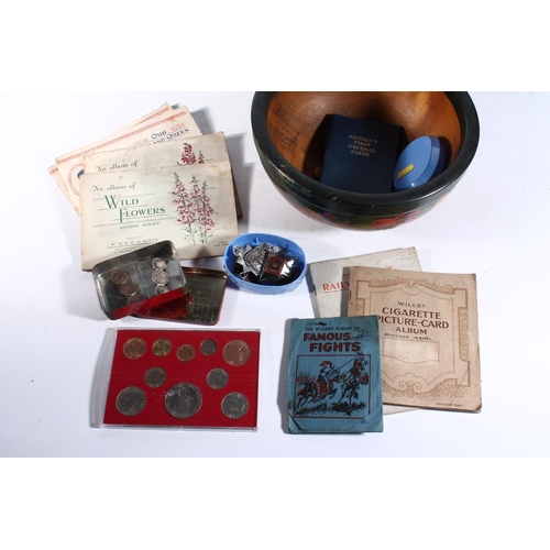 241 - Wooden painted fruit bowl, coins, cigarette cards, vintage badges and a bone needle case.