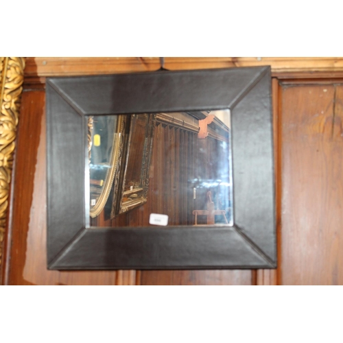 686 - Leather framed wall mirror.