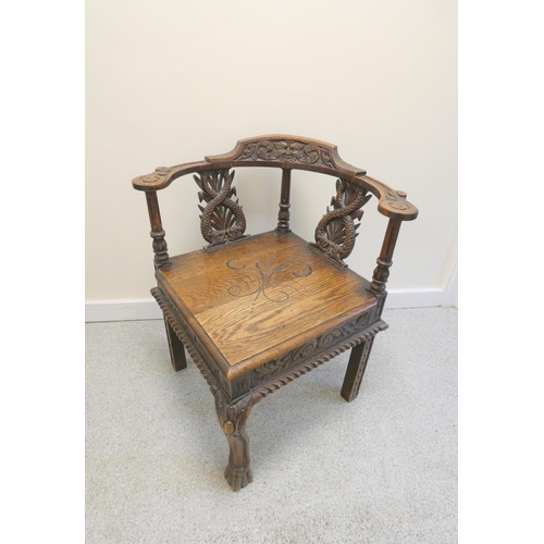 344 - Carved oak corner chair with mask to the top rail above repousse splats and central turned column, t... 