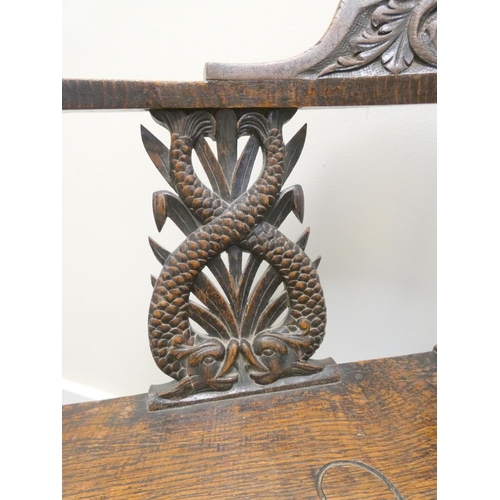 344 - Carved oak corner chair with mask to the top rail above repousse splats and central turned column, t... 