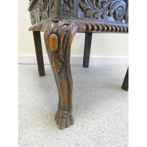 344 - Carved oak corner chair with mask to the top rail above repousse splats and central turned column, t... 