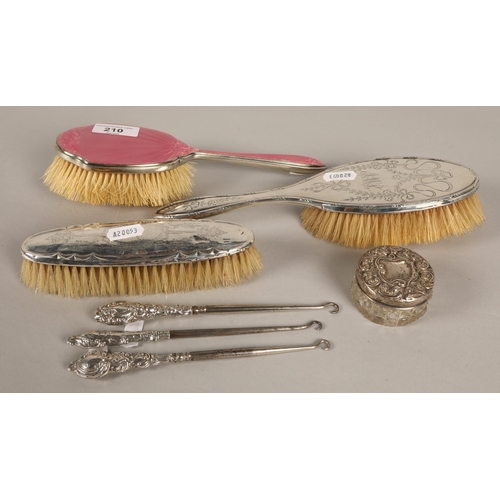 210 - Assorted silver dressing table items including brush set, a pink enamelled brush, three button hooks... 