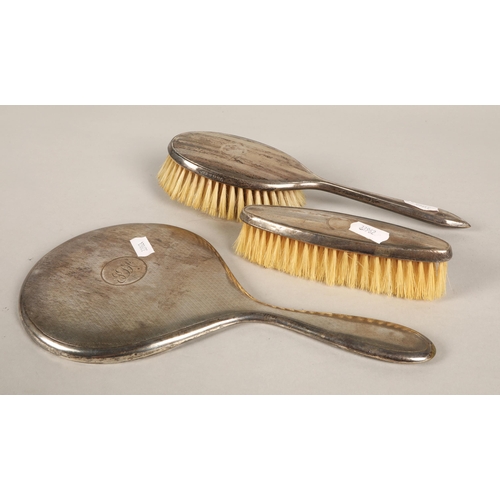 214 - Silver mirror and two piece brush set, hallmarked London 1930, Birmingham 1934 and 1932 respectively