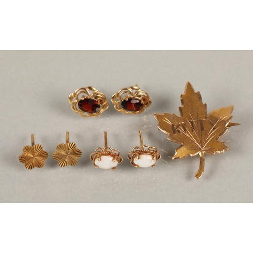 98 - A 10kt gold maple leaf brooch, a 9kt gold pair of stud earrings set with red gems, another pair ille... 