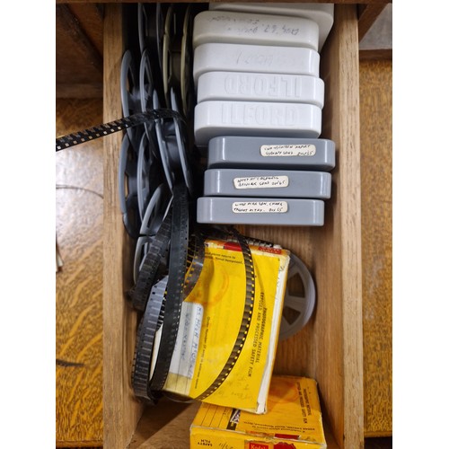 670 - A stack of three wooden filing drawers containing large quantity of film reels, photographic slides,... 