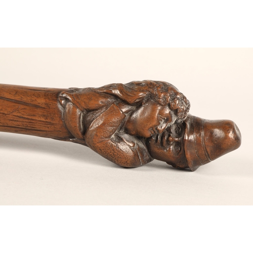 35 - Double ended carved wooden stick with couple embracing at one end, 50cm long