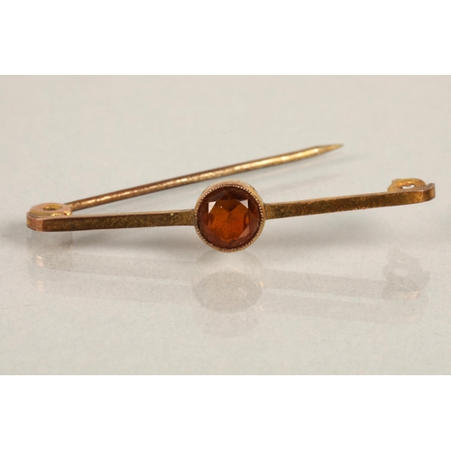 68 - Yellow metal bar brooch with illegible markings set with an orange gem, a yellow metal brooch set wi... 