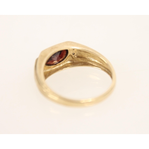 400 - Gents 9ct gold ring set with oval cut garnet and flanking diamonds, size U/V, 3.8g.