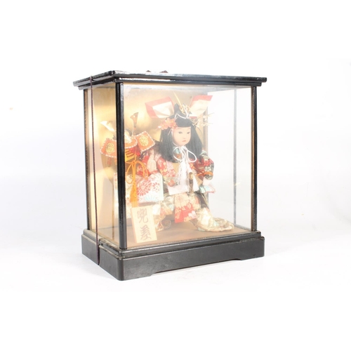 181 - Japanese doll of a Samurai in glazed case, 33cm high.