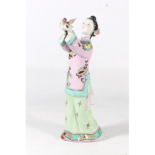 29 - Modern Chinese porcelain figurine of a young girl holding a bird, 39cm high.