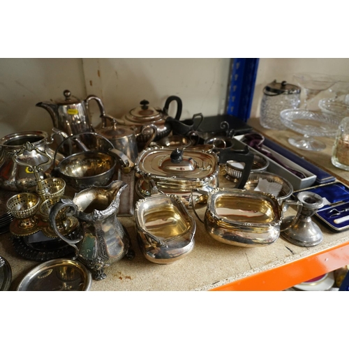 378 - Shelf containing silver plate to include a three piece teaset, napkin rings, candlesticks, coasters,... 