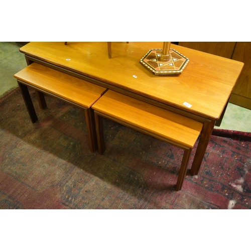 573 - Teak coffee table with nesting two smaller tables below, 122cm wide.