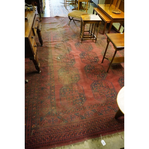 592 - Red ground Turkamen carpet with central field decorated with three rows of seven gul and multi-borde... 